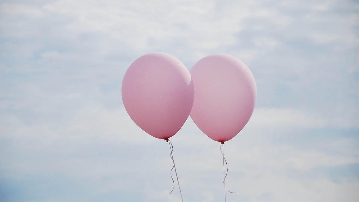 zwei-luftballons-fliegen-im-wind