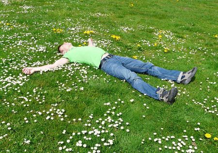 mann liegt entspannt auf wiese