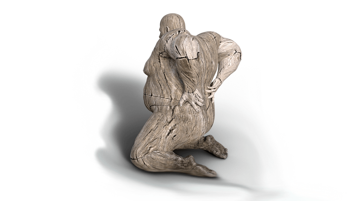 mann rueckenschmerzen holzfigur