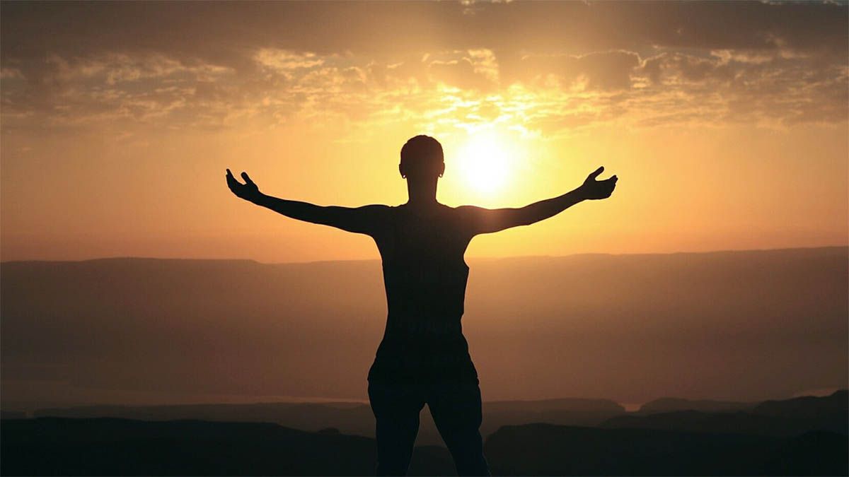 Ganzheitliche Gesundheit mann-siegerpose-sonnenuntergang