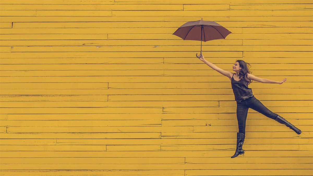 frau-gelbe-wand-regenschirm
