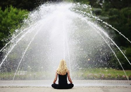 frau meditieren springbrunnen