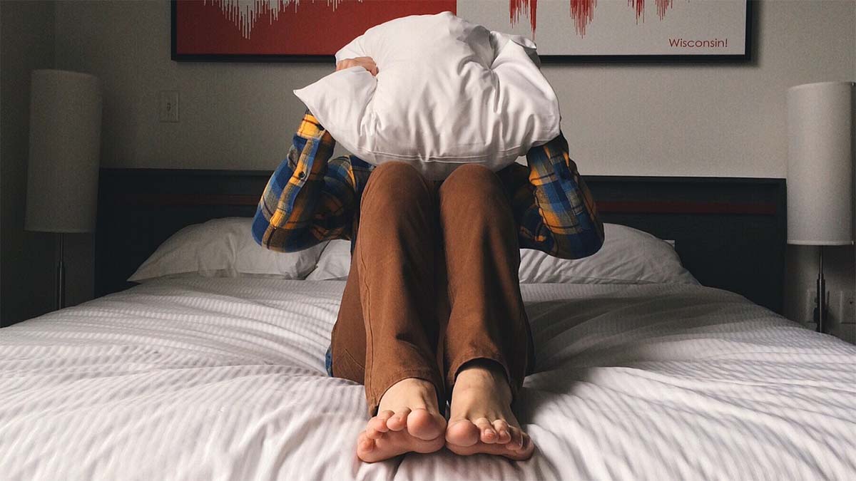 Einschlafprobleme trotz Müdigkeit bett-kissen-ueber-kopf