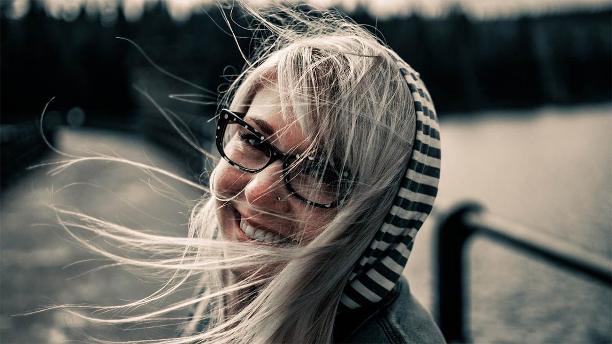 frau-blond-brille-haare-im-wind
