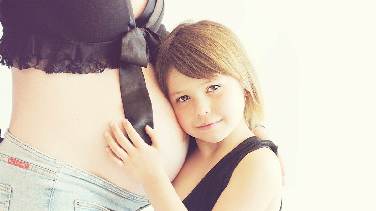 kind-haelt-babybauch-fest