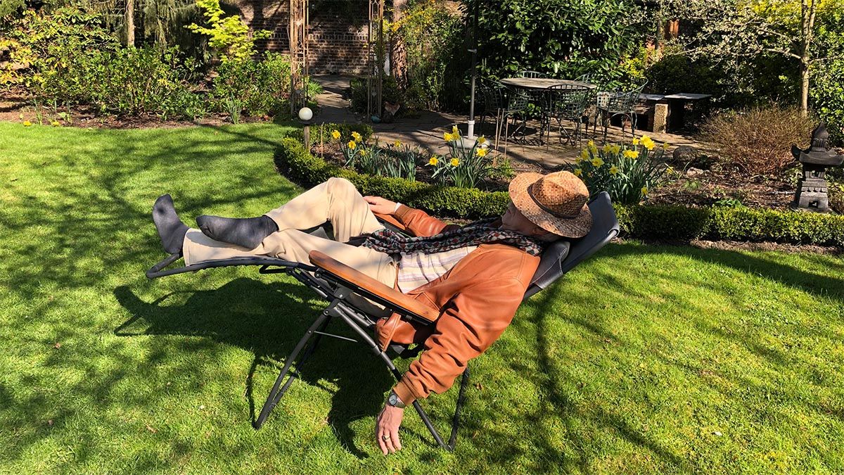 mann-liegt-auf-klappstuhl-im-garten