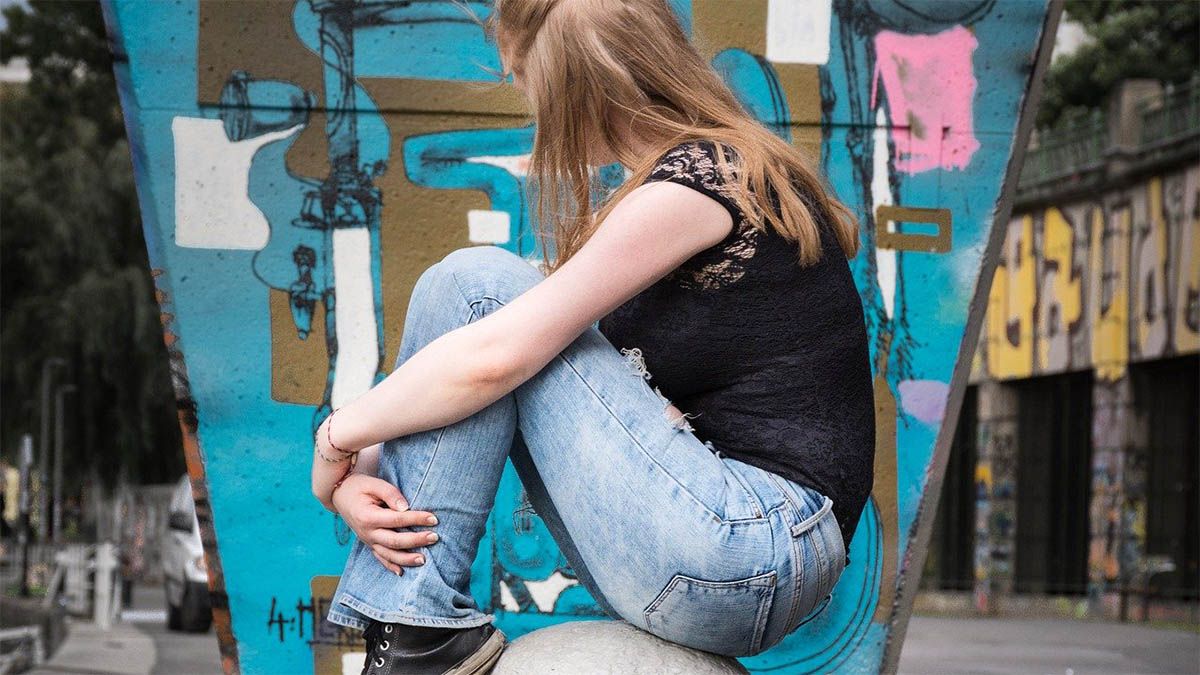 maedchen-traurig-sitzt-auf-stein
