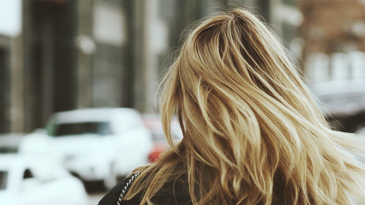 5 Tipps für schönere Haare – so sehen Sie schon bald Erfolge frau blond haare strasse mit autos
