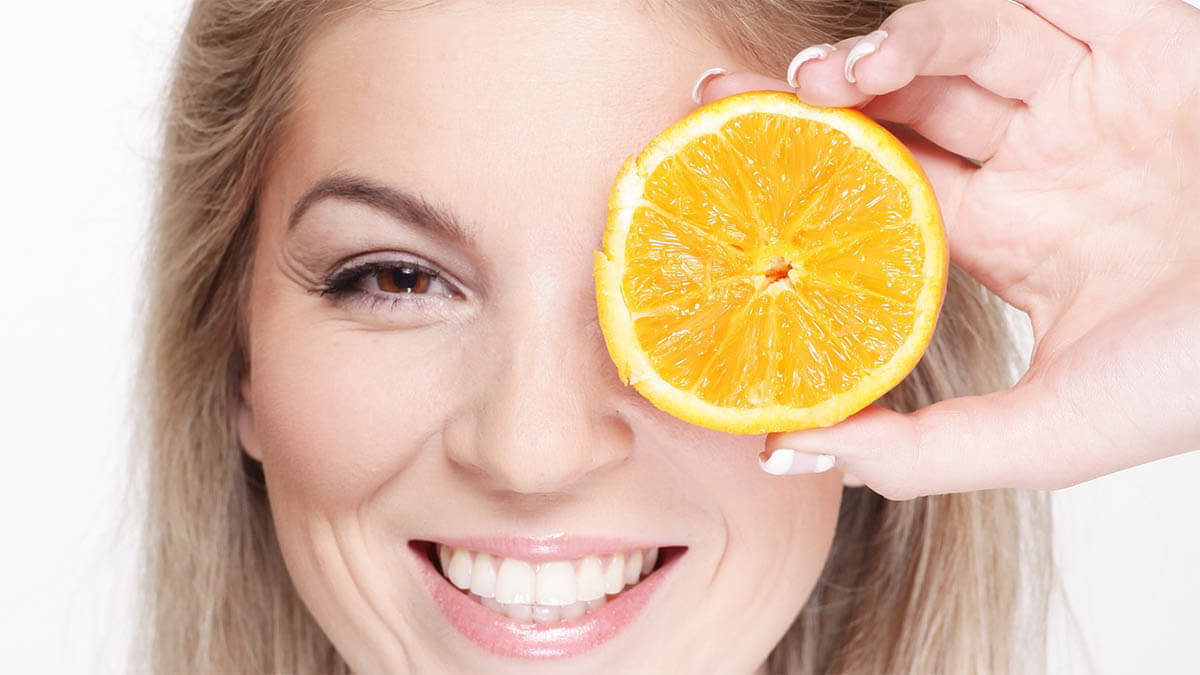 frau-haelt-sich-orange-vor-auge