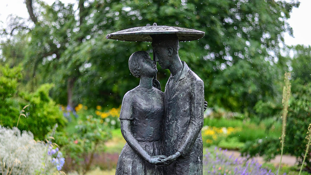 statue-mann-frau-verliebt-garten-regenschirm