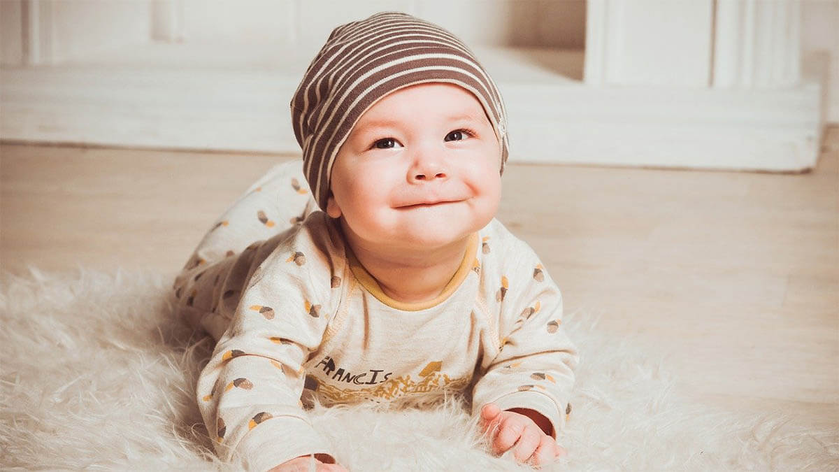 baby-mit-muetze-lacht