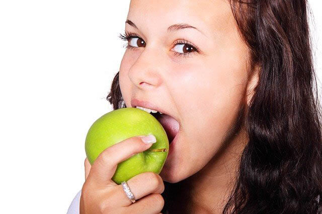 frau beisst in apfel klein