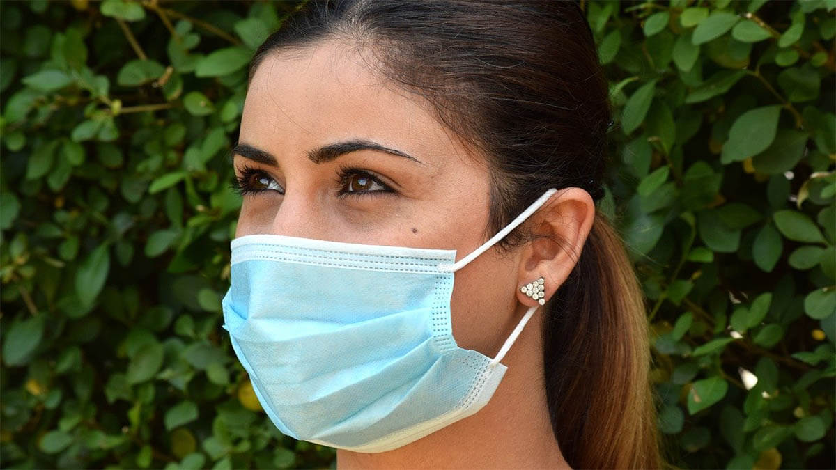 frau mundschutz maske corona an