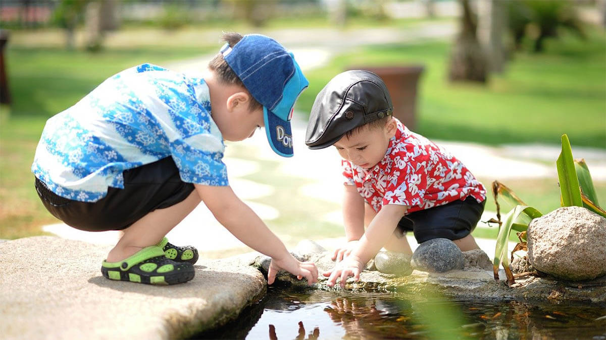 kinder spielen am teich an