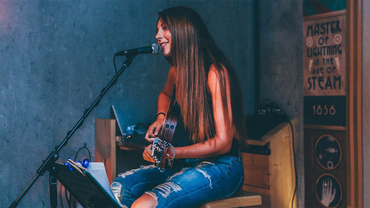 frau mit gitarre macht musik an