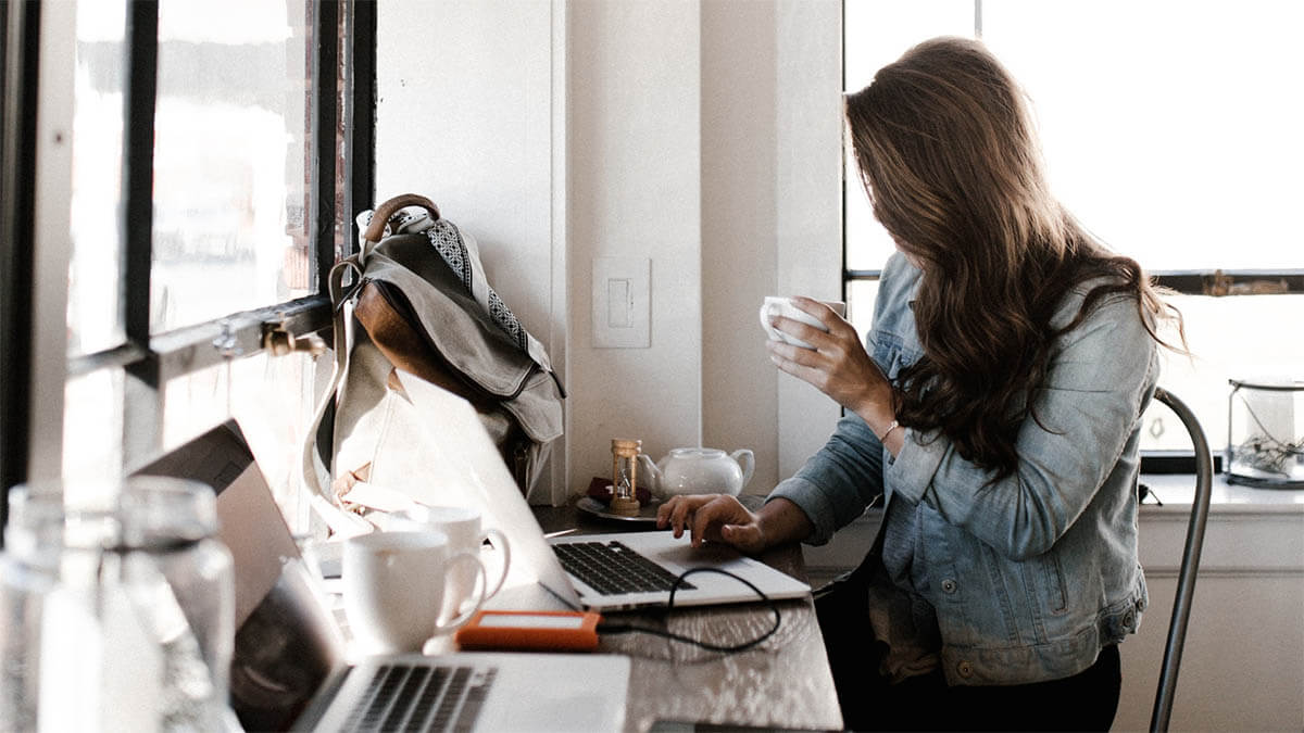 frau laptop trinkt kaffee