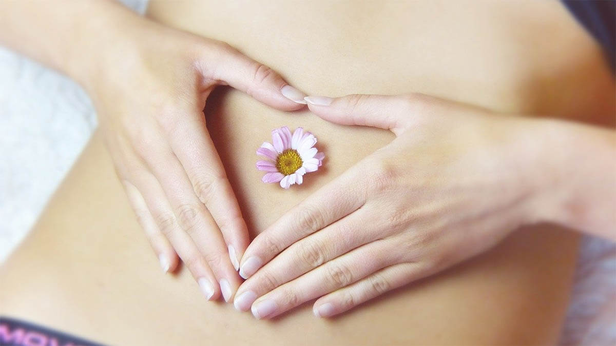 frau bauch herz hand gaensebluemchen