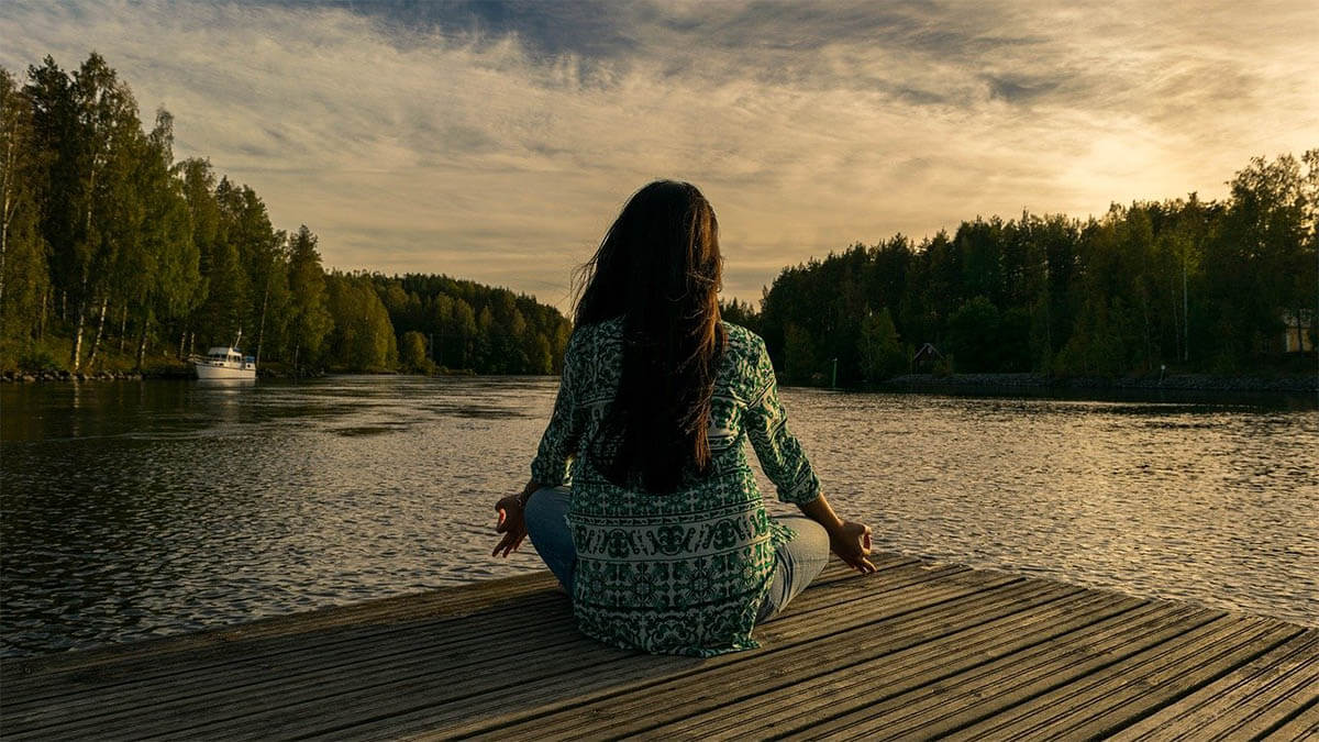 frau meditation am see