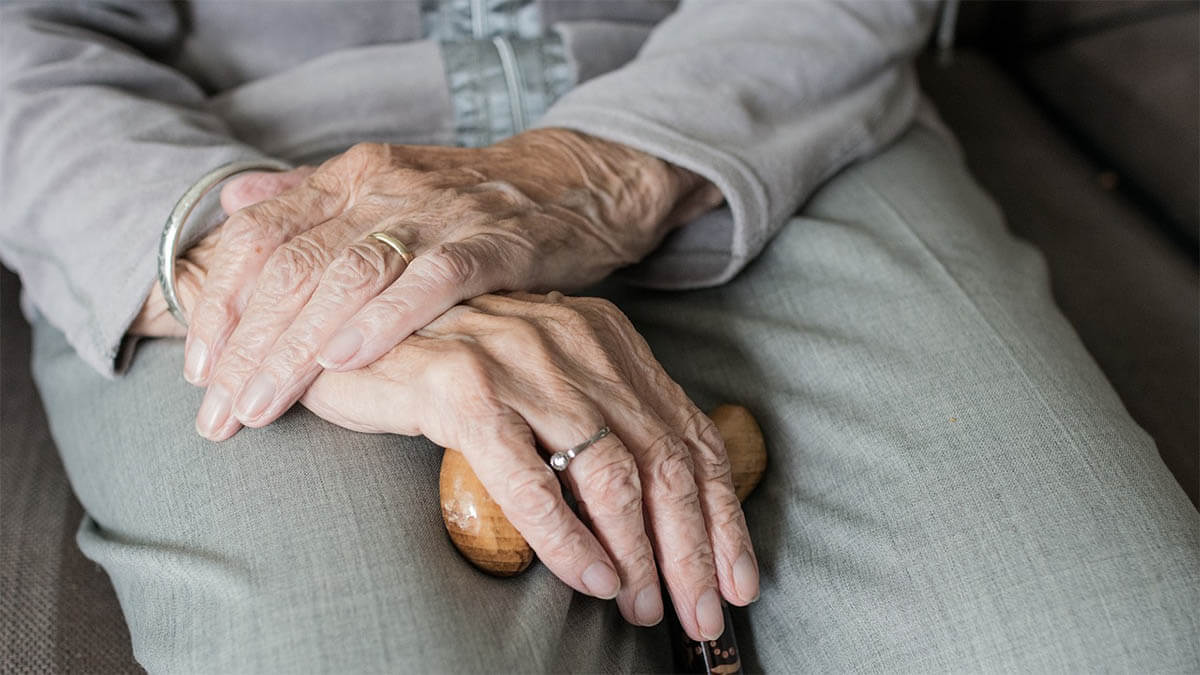 alte frau sitzt mit stock an